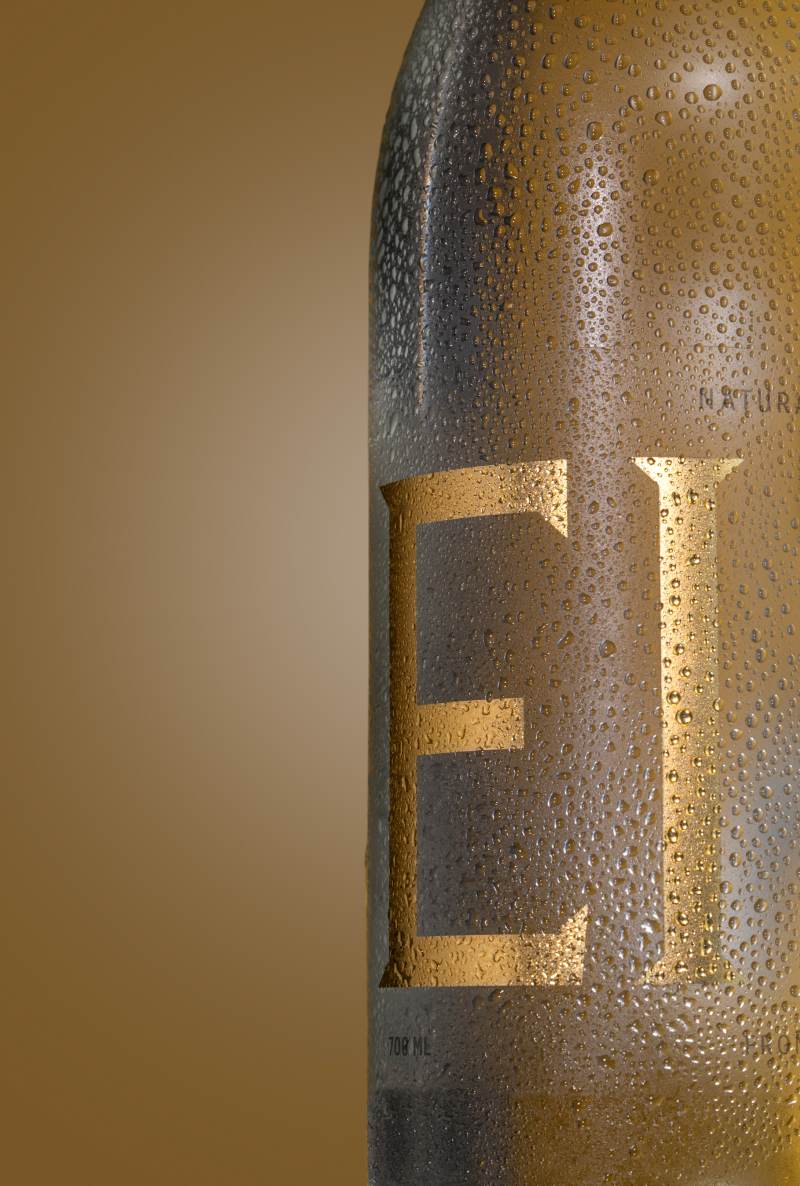 Close-up of a chilled Eira Natural Mineral Water bottle covered in refreshing condensation droplets.