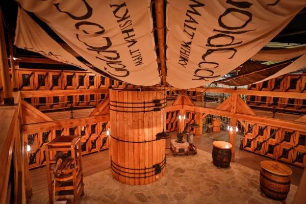 Interior of the Gold Cock Czech whisky distillery featuring oak barrels, wooden architecture and traditional whisky production.