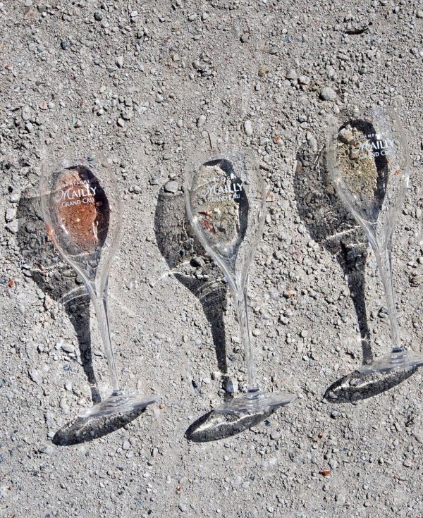 Three Mailly Grand Cru branded Champagne flutes displayed outdoors, representing premium Champagne tasting and celebration.
