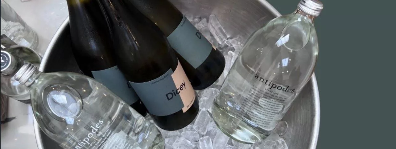 Dicey wines and Antipodes sparkling water chilling on ice, showcasing premium New Zealand wine and beverage pairing.