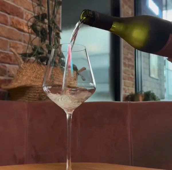 White wine being poured into a wine glass, highlighting the fresh and elegant character of Dicey Wines.
