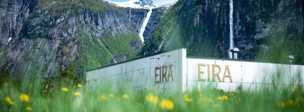 Eira Natural Mineral Water production facility surrounded by Norway's pristine mountains and waterfalls, reflecting the brand's natural source.