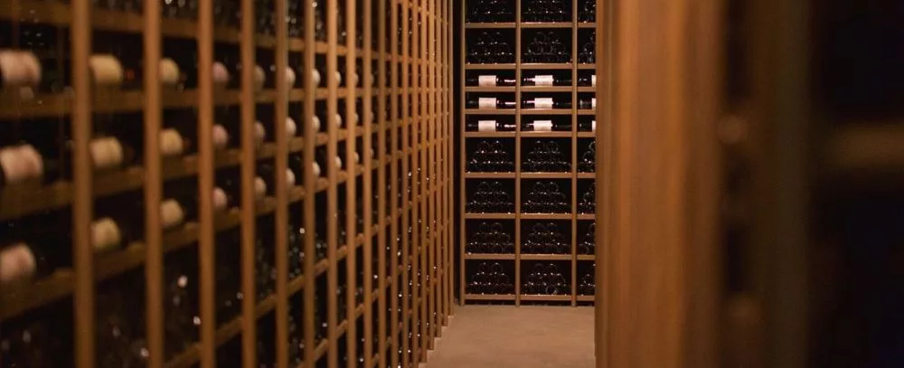 Franck Bonville wine cellar showcasing carefully stored bottles in premium wooden racks.