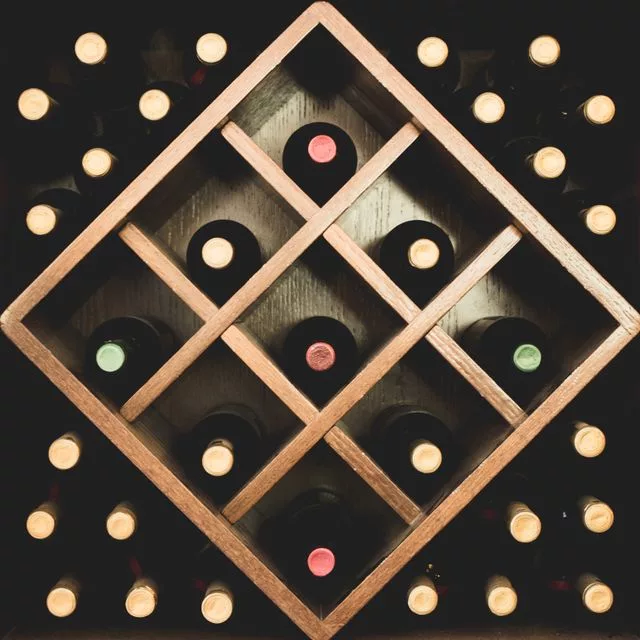 Wooden wine rack displaying a curated collection of Franck Bonville wines in cellar storage.